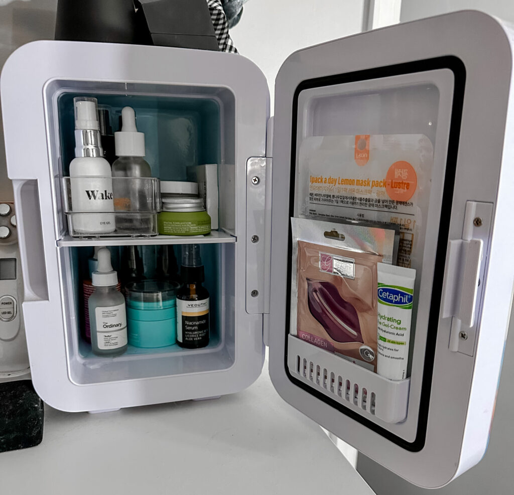 An open Beauty Fridge with products inside on a white surface