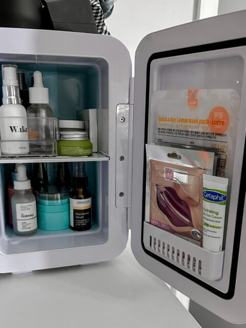 An open Beauty Fridge with products inside on a white surface