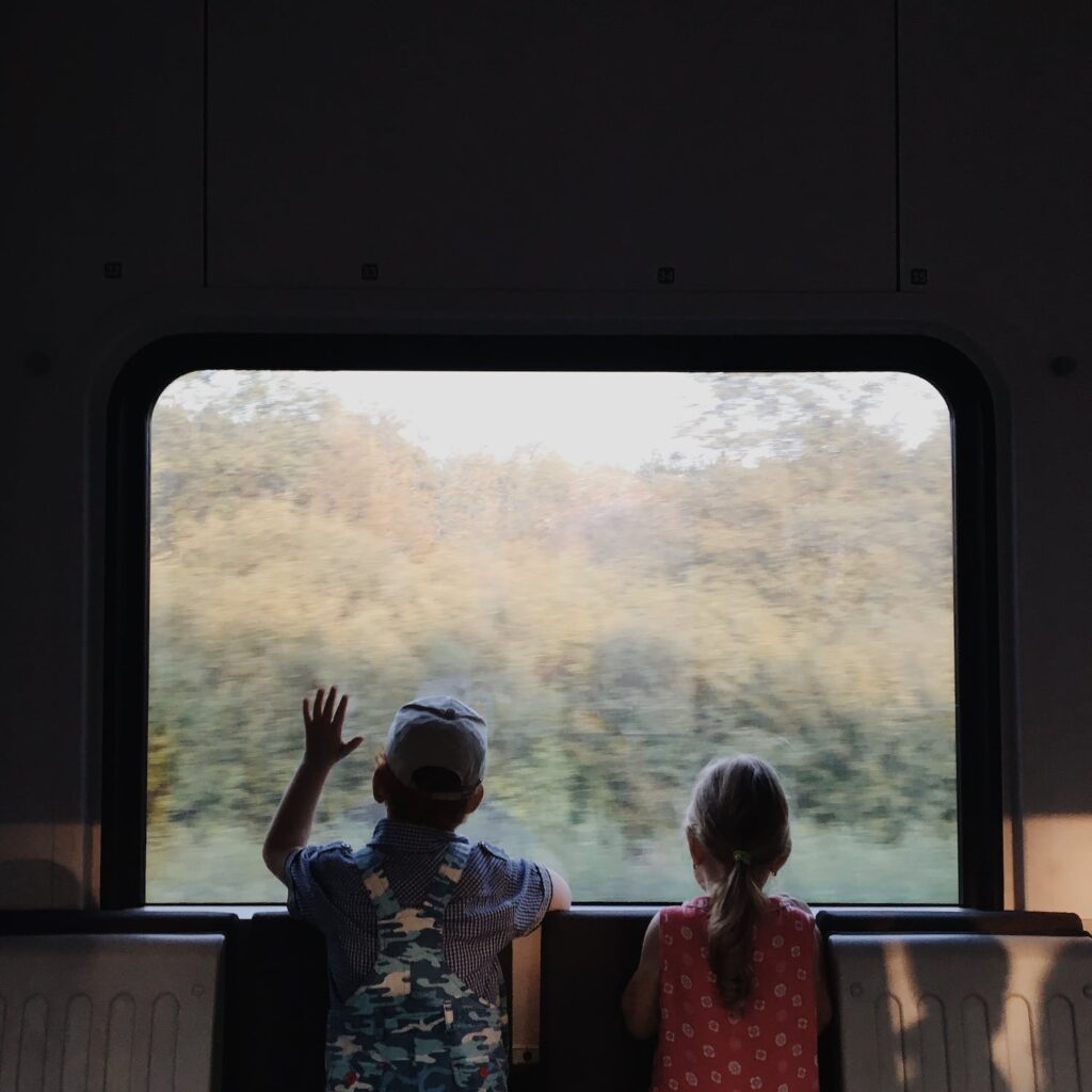 a boy and girl looking outside the window