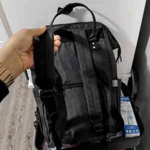 Hand holding the straps of a Dark Grey Backpack style Diaper bag